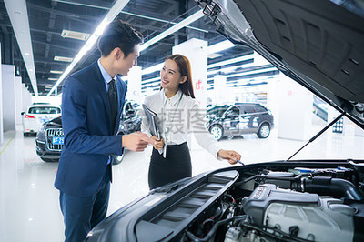 汽車銷售服務人員為客戶介紹汽車