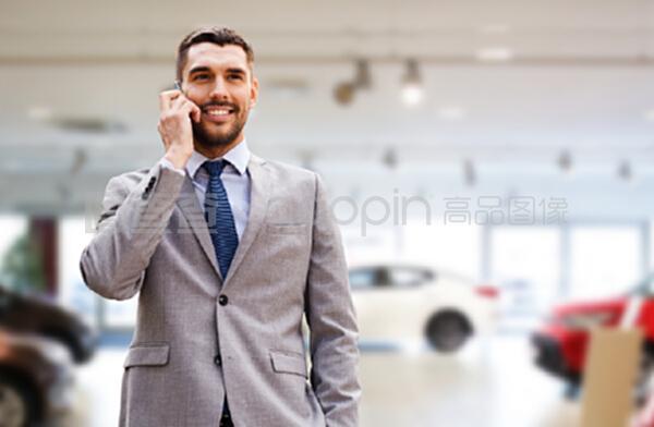 汽車業務,汽車銷售,手勢和人的概念-微笑的商人在智能手機上談論汽車展示背景